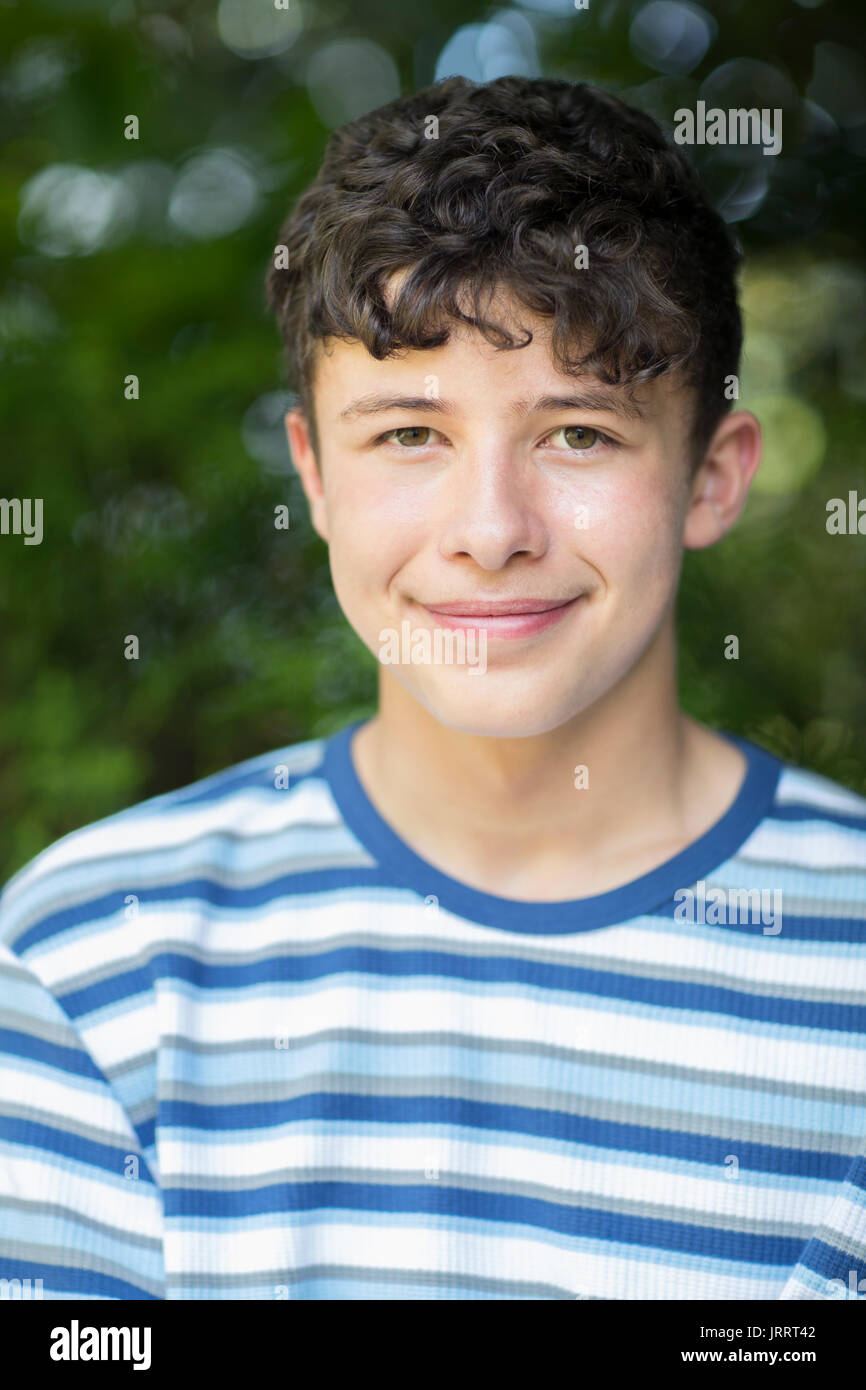 Portrait Of Happy Young Boy Sitting Outdoors Banque D'Images