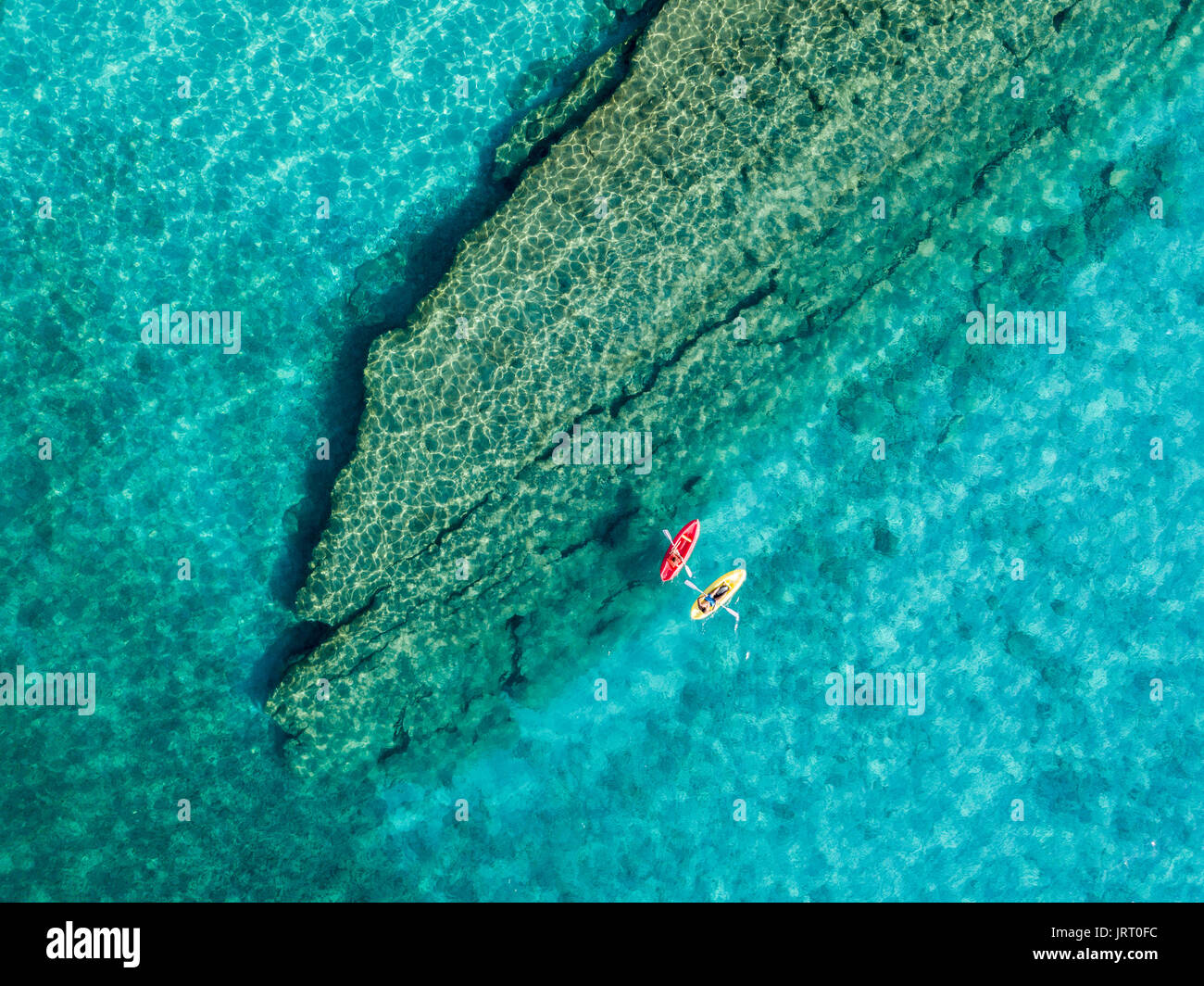 Vue aérienne d'un canoë dans l'eau, flottant sur une mer transparente. Les baigneurs en mer. Tropea, Calabre, Italie. Détente et plongée vacances d'été. Banque D'Images