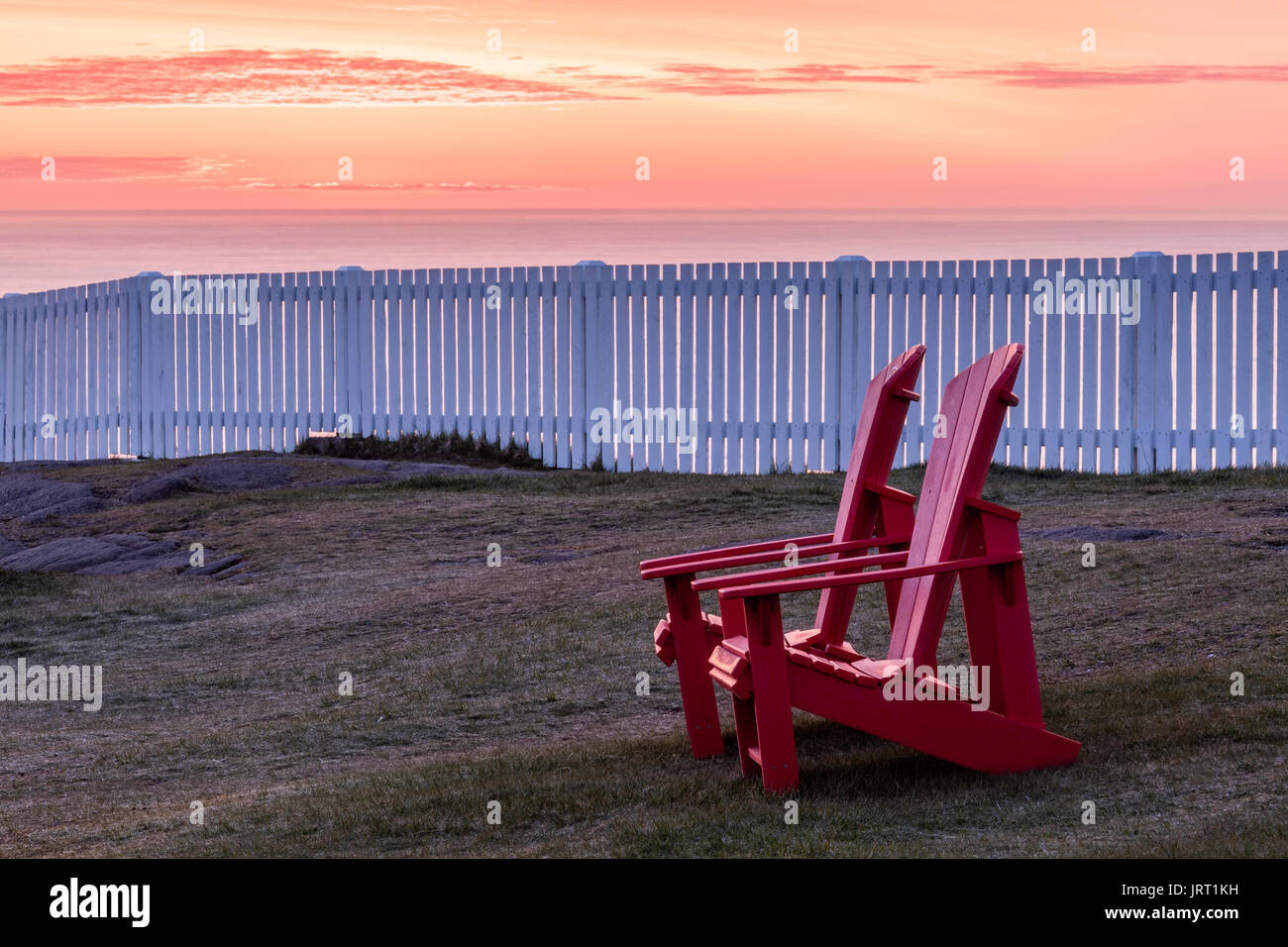 Deux chaises Muskoka rouge avec une vue sur l'océan Atlantique au lieu historique national du Canada du Cap-Spear au lever du soleil. Cape Spear, à Terre-Neuve. Banque D'Images