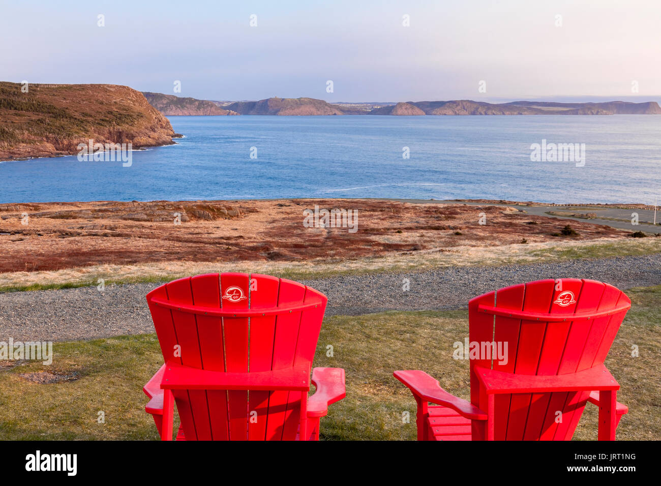 Deux chaises Muskoka rouge avec une vue sur l'océan Atlantique en direction de la ville de Saint John's au lieu historique national du Canada. Banque D'Images
