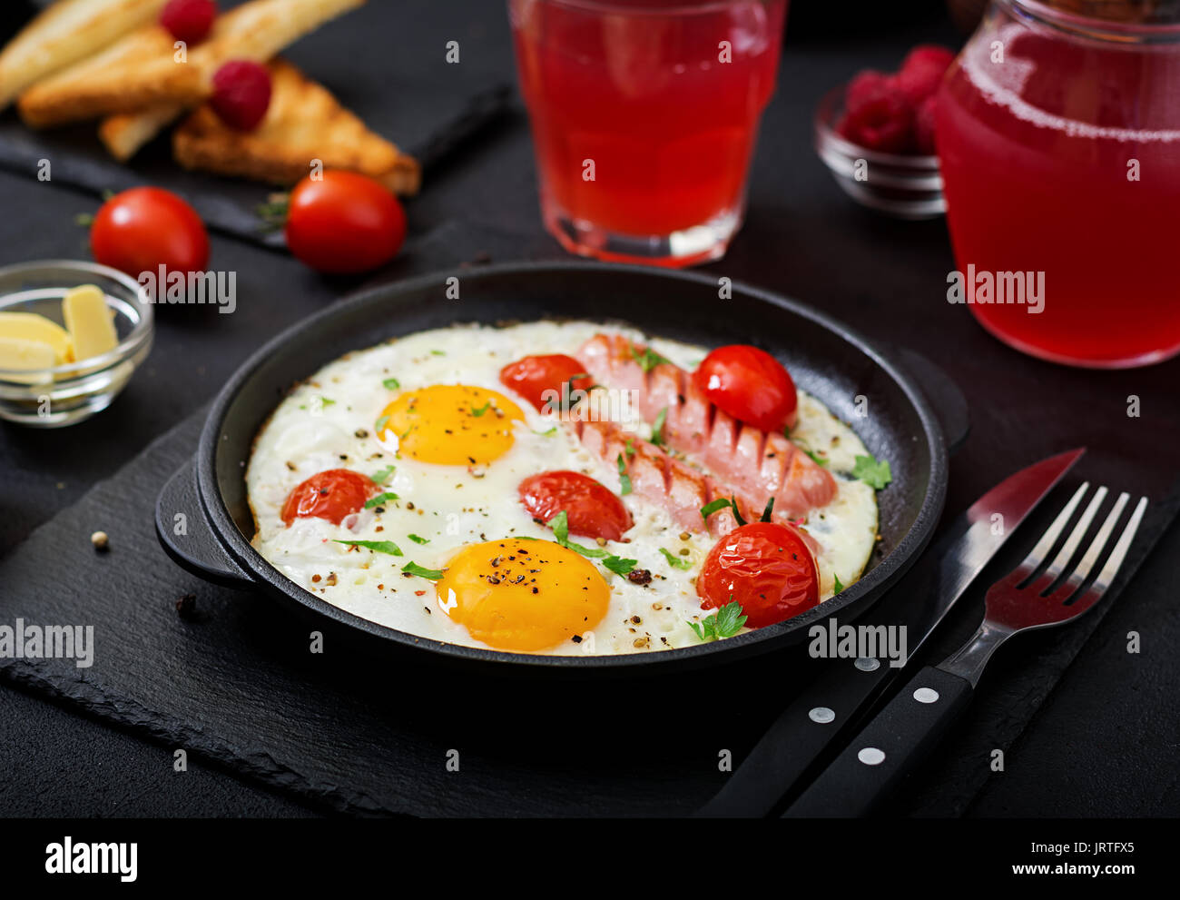 Petit-déjeuner anglais - œuf frit, tomates et saucisses. Banque D'Images