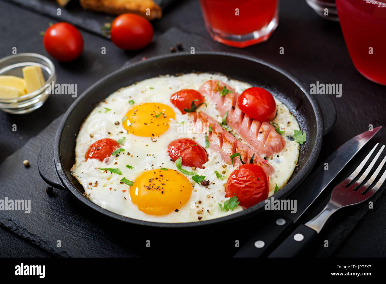 Petit-déjeuner anglais - œuf frit, tomates et saucisses. Banque D'Images