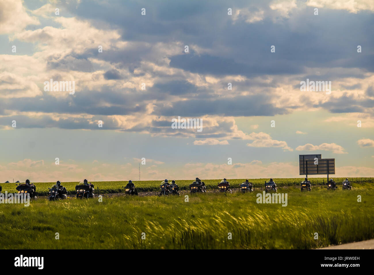 Groupe de motocyclistes équitation seul fichier dans le Kansas, USA ; ciel nuageux au-dessus d'eux Banque D'Images