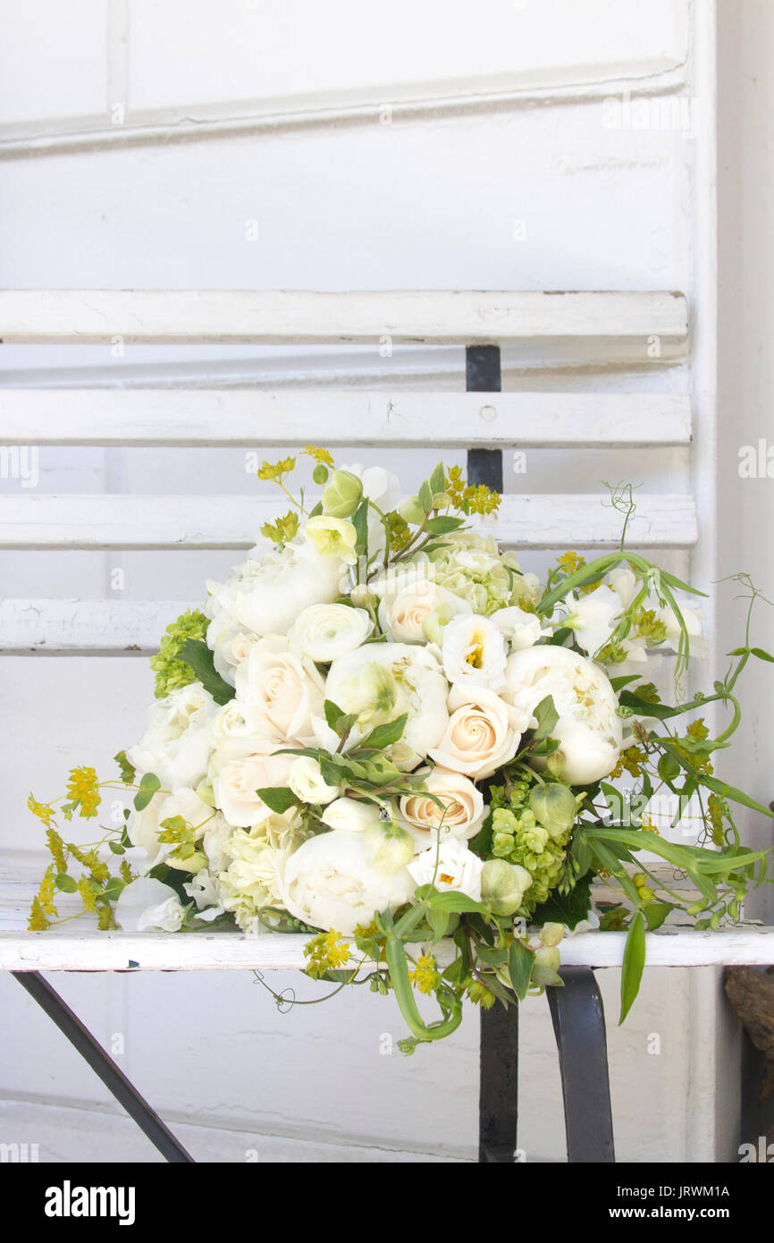 Bouquet de fleurs vert et blanc couché sur un vieux banc en bois blanc Banque D'Images Bouquet de fleurs vert et blanc couché sur un vieux banc en bois blanc Banque D'Images