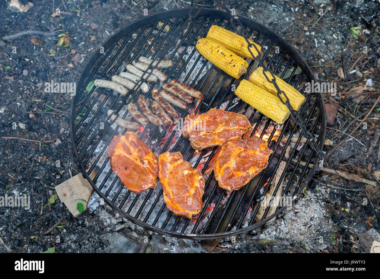 Viande, saucisses et épis de maïs sur le grill fire Banque D'Images