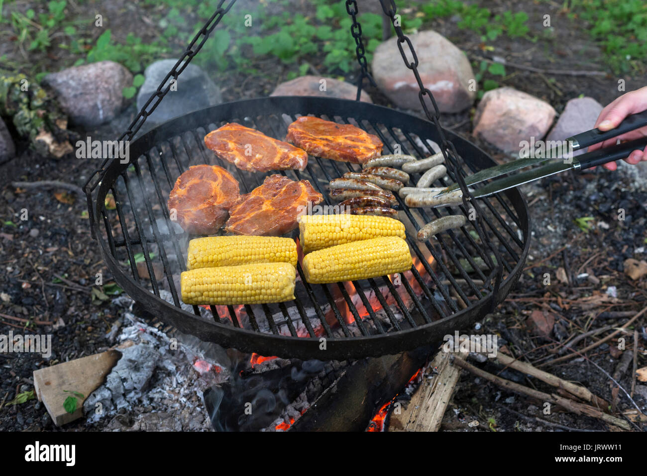 Viande, saucisses et épis de maïs sur le grill fire Banque D'Images