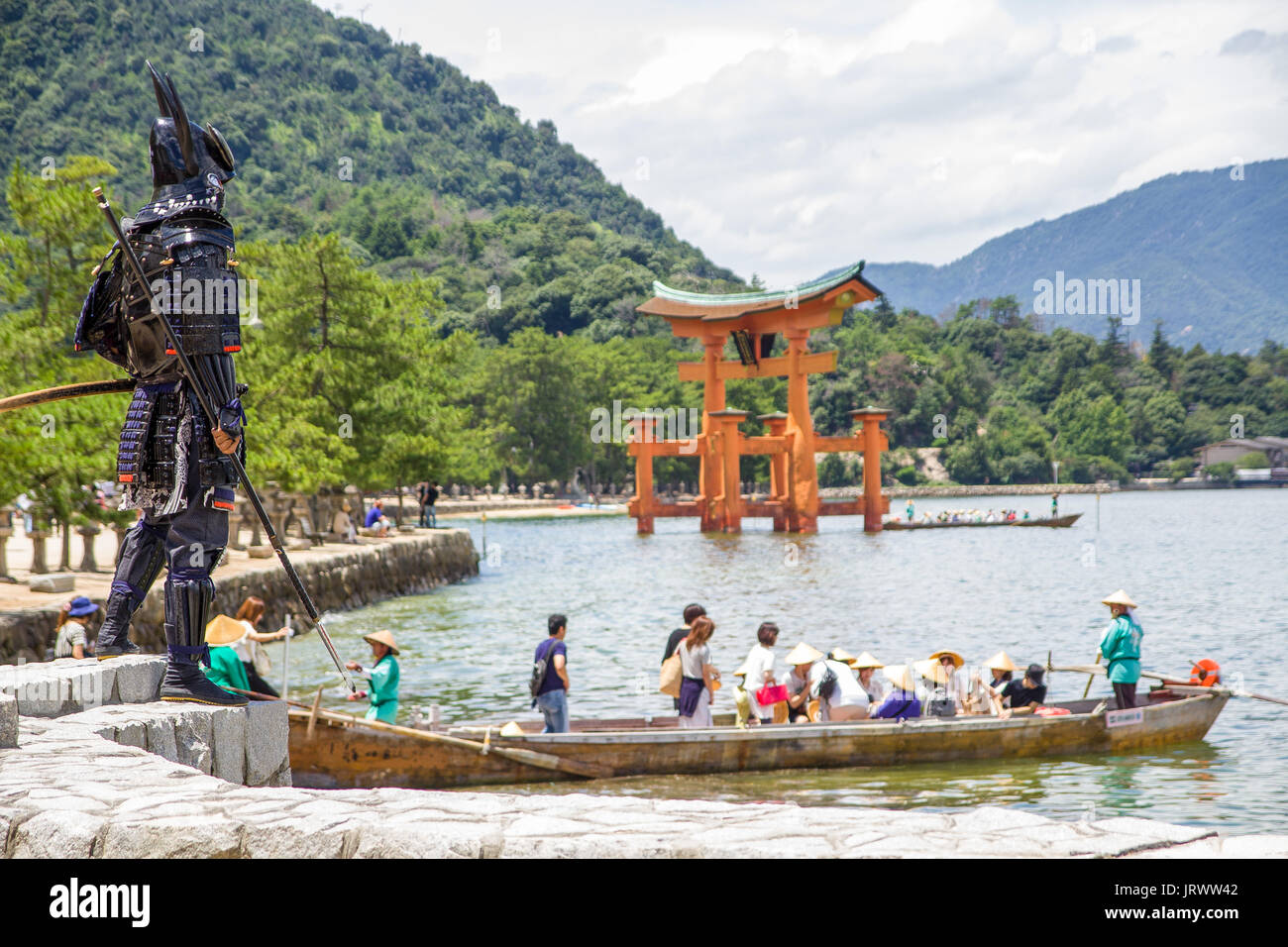 Un samouraï pose près de l'Itsukushima torii flottant à Banque D'Images