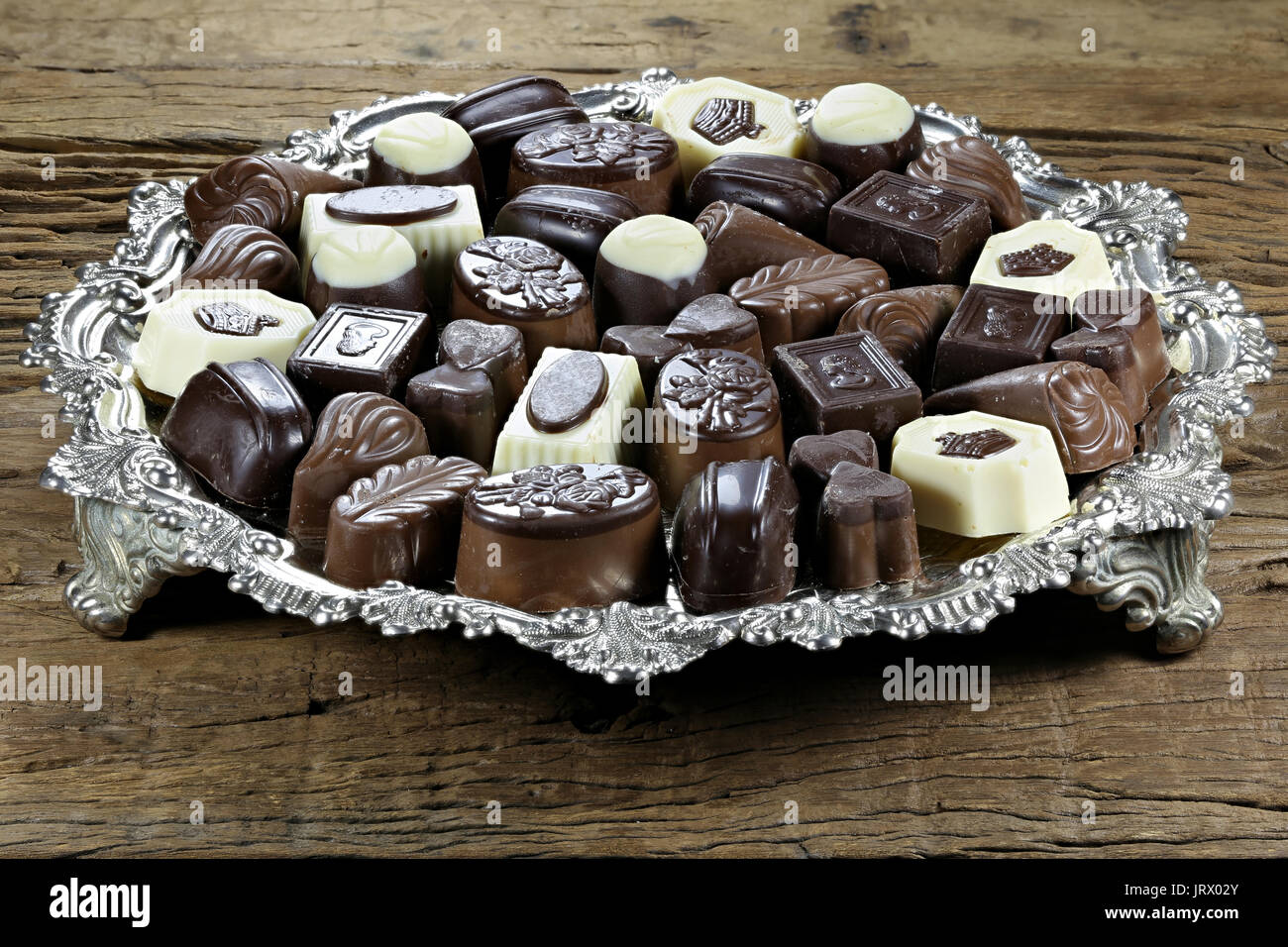 Plateau d'argent avec des pralines au chocolat belge sur fond de bois rustique Banque D'Images