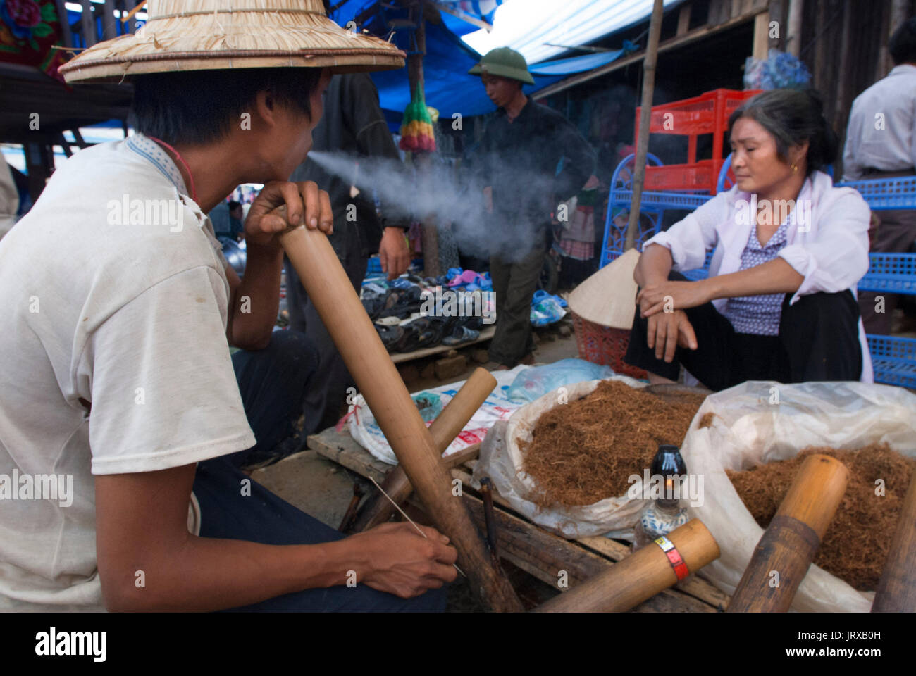 Un homme fumeurs de tabac à bac ha marché, SAPA, Vietnam Banque D'Images