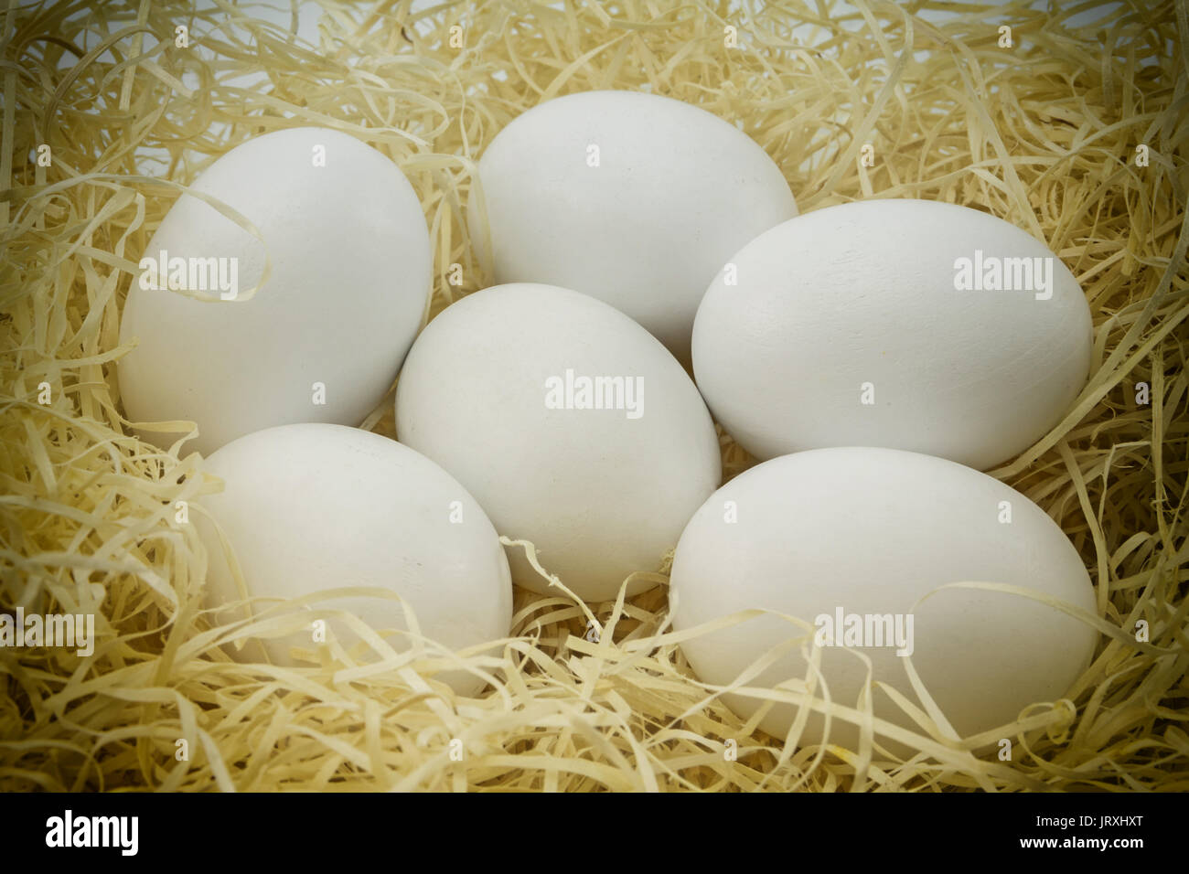 Close-up white les oeufs de poule sur un lit de paille Banque D'Images