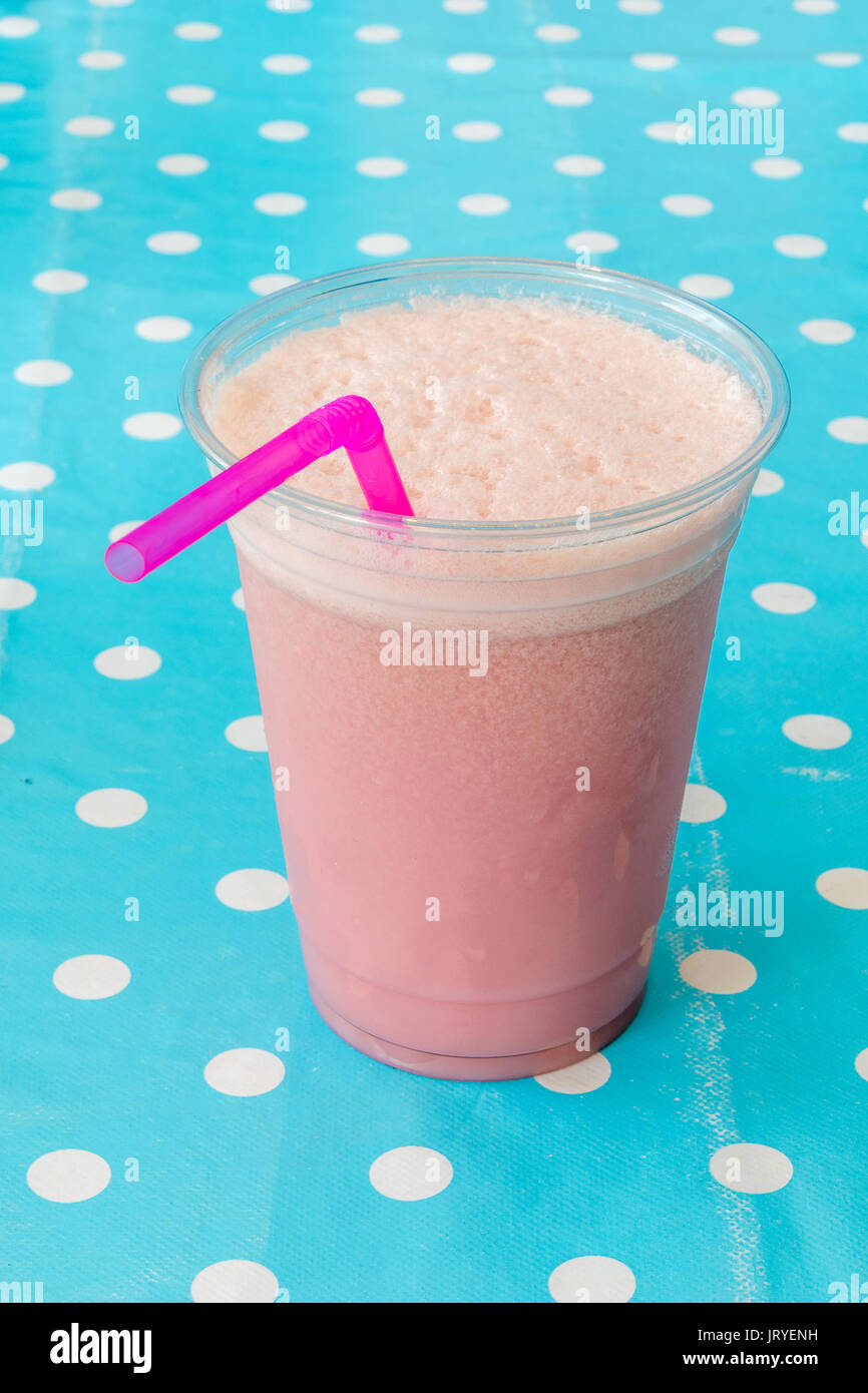 Smoothie aux framboises dans une tasse en plastique avec paille rose Banque D'Images