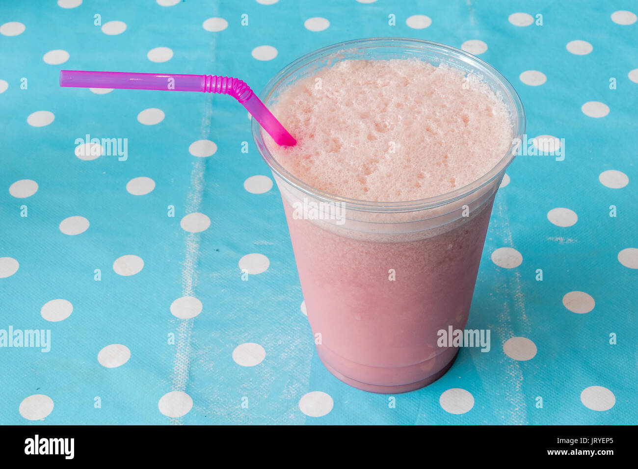 Smoothie aux framboises dans une tasse en plastique avec paille rose Banque D'Images