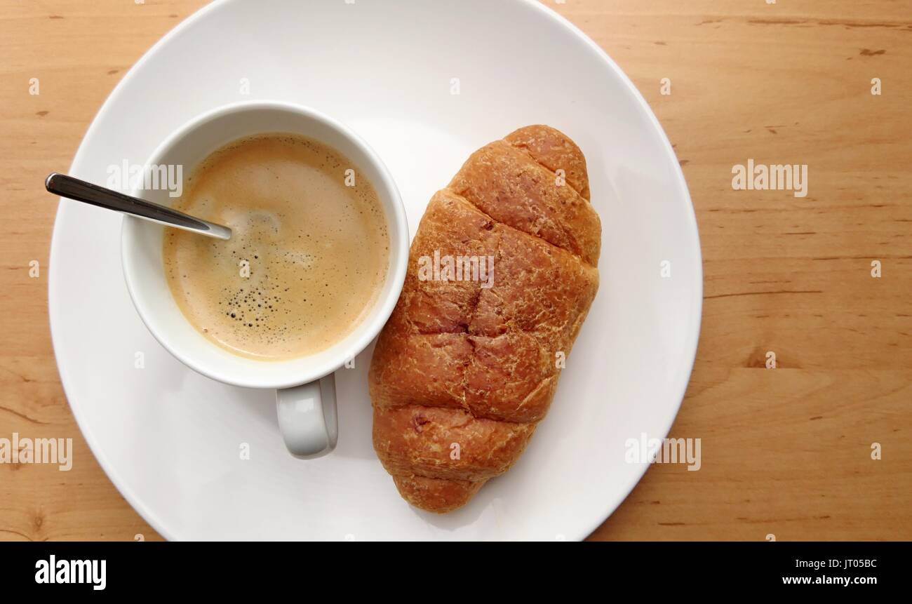 Le petit-déjeuner avec café et des croissants frais sur une assiette blanche. Banque D'Images