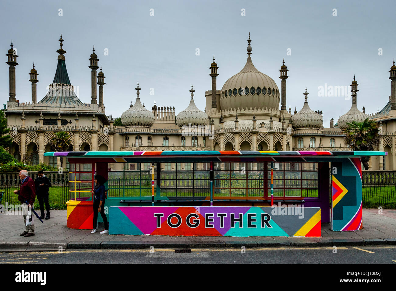 Les personnes en attente d'un Bus à un abri bus peintes de couleurs vives, Brighton, Sussex, UK Banque D'Images