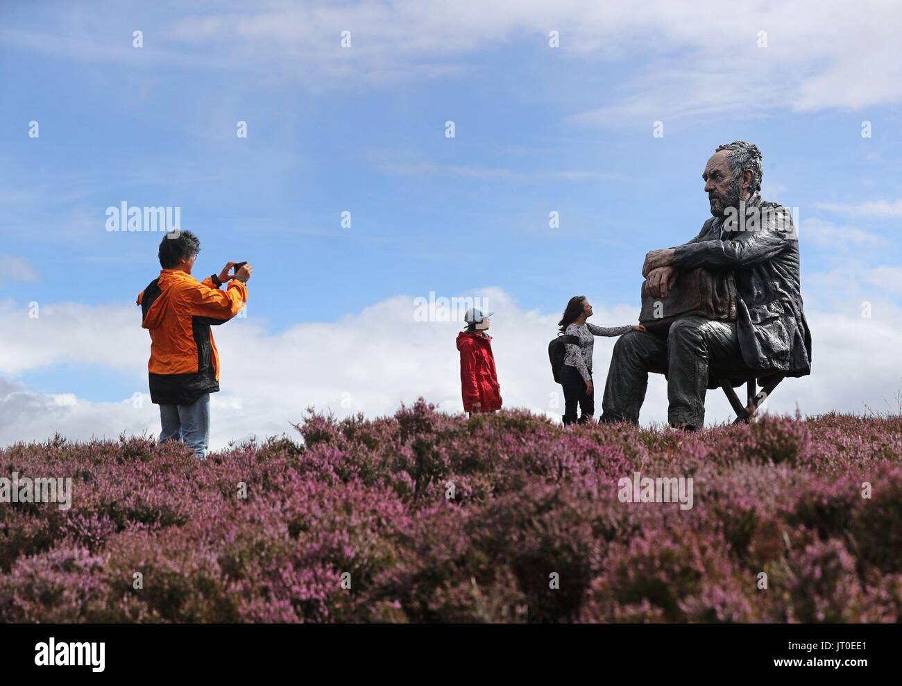 Hyunbea Jung (12) Centre de Castleton et Eve Clarke (à droite) de Hexham 11 regarder la homme assis, une sculpture de 3 mètres par Sean Henry, à Castleton Rigg, près de Westerdale dans le North York Moors National Park. Banque D'Images