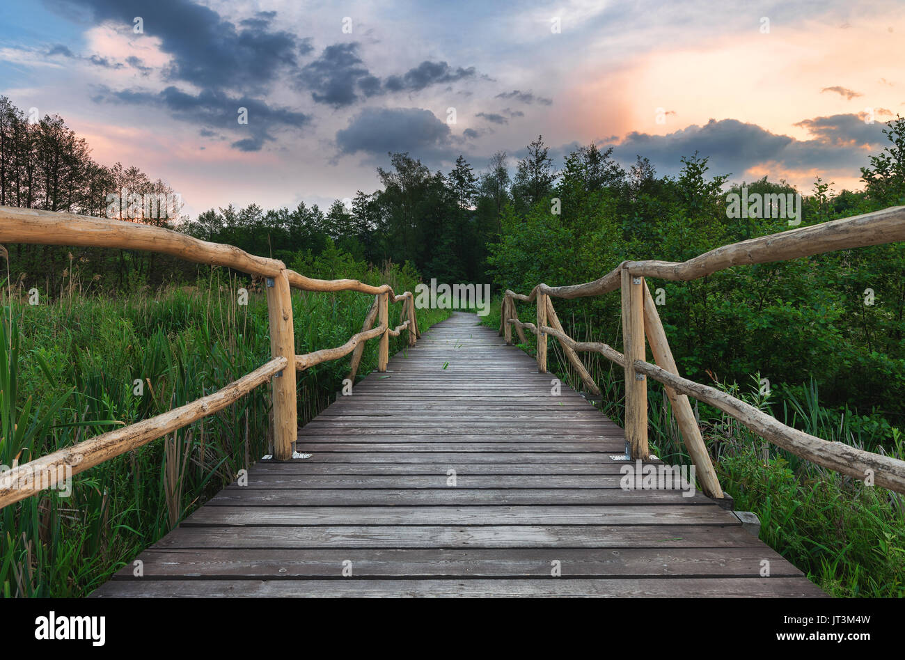 Chemin de bois pont sur le lac au coucher du soleil après la tempête Banque D'Images