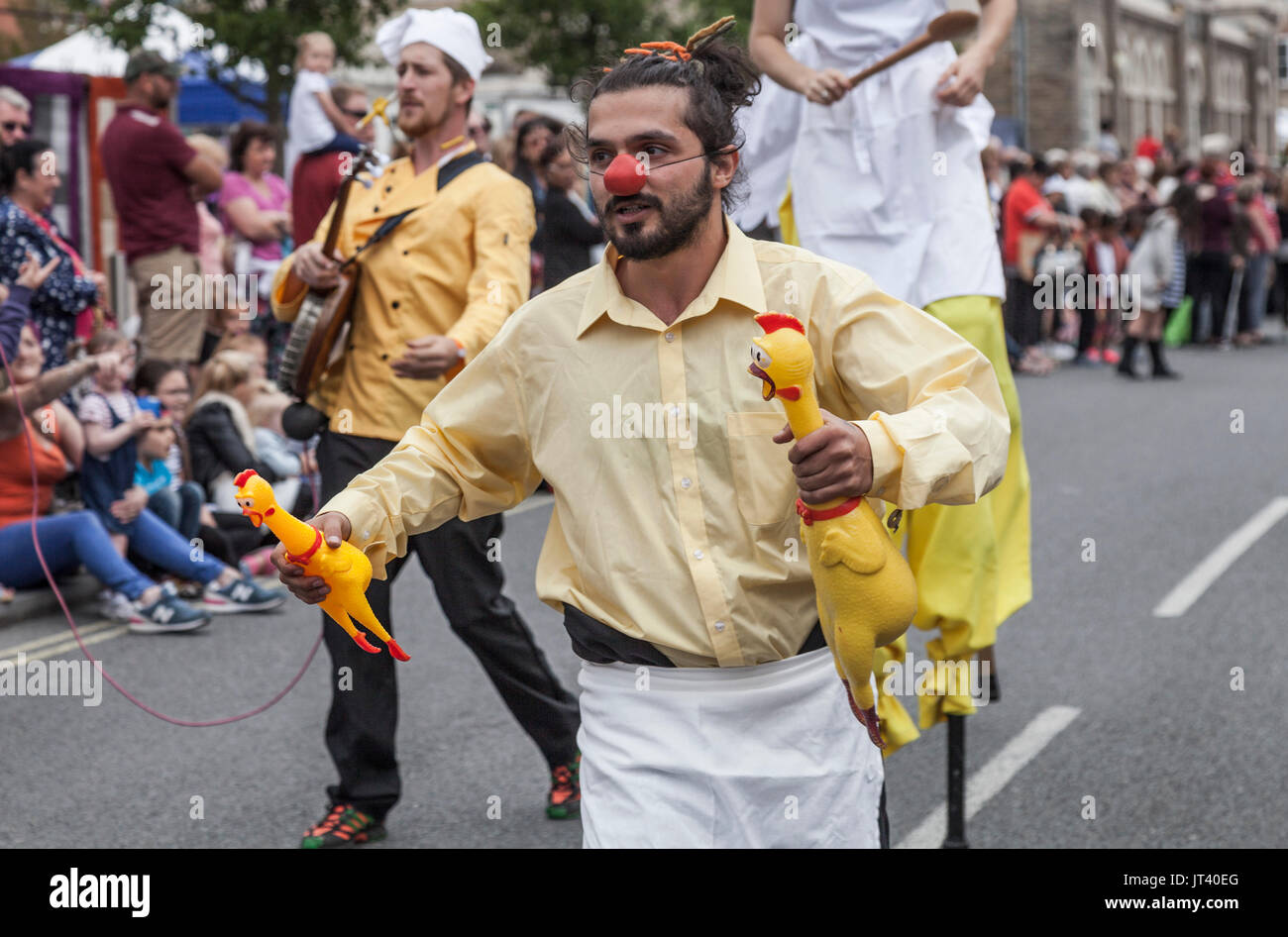 Un homme portant un nez rouge et portant des poulets au jouet Stockton International Riverside Festival Parade Banque D'Images