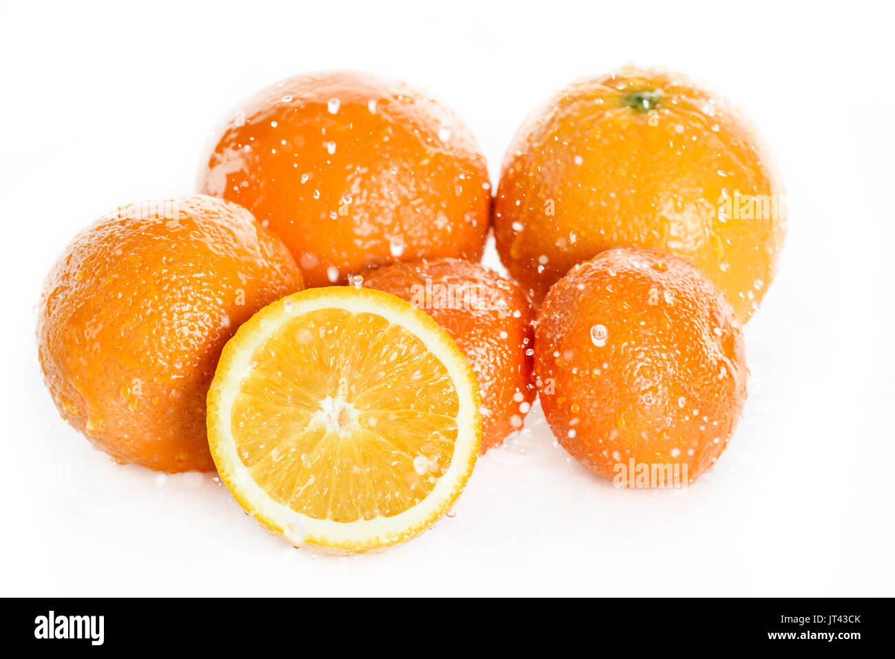 Vue rapprochée d'oranges frais mûrs avec de l'eau gouttes isolé sur blanc, les fruits de tomber dans de l'eau splash Banque D'Images