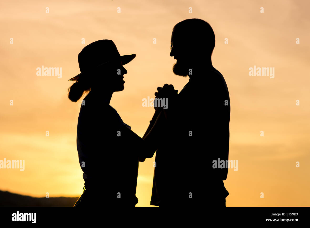 Silhouette d'un couple à l'heure d'or de soleil romantique Banque D'Images