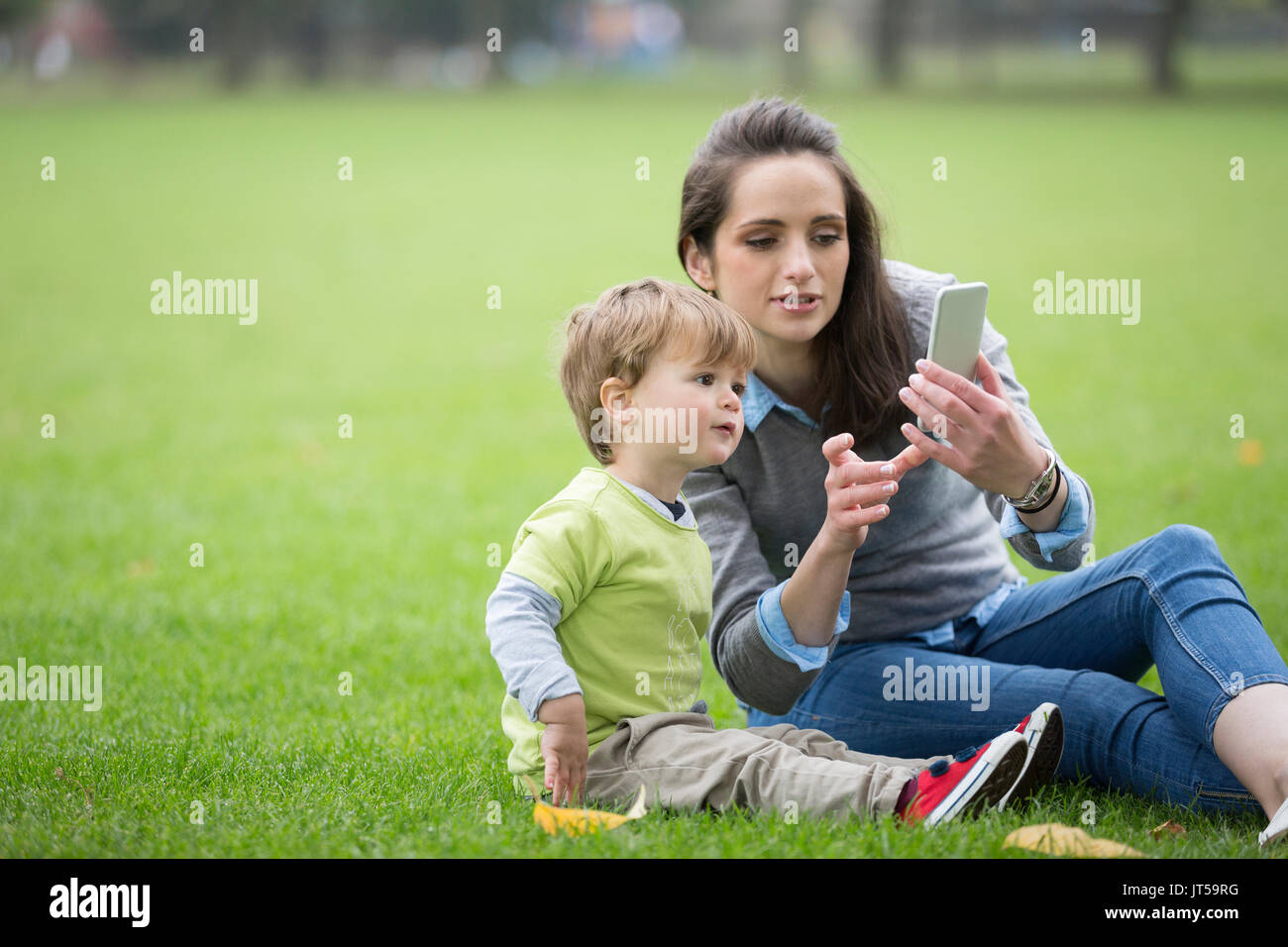 Heureuse mère jouant avec son petit garçon à l'extérieur. L'amour et l'unité concept. Banque D'Images