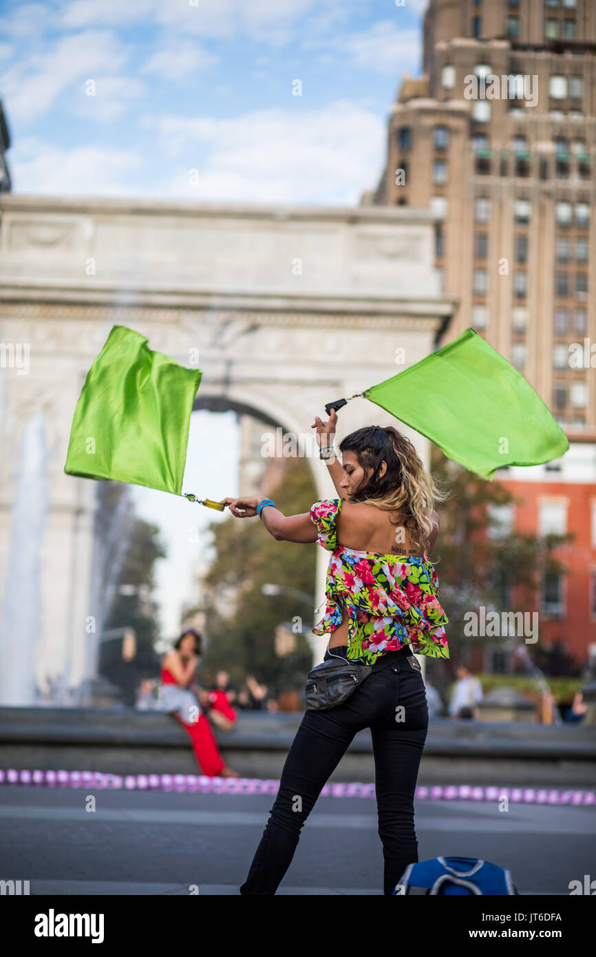 NEW YORK, USA - Le 17 octobre 2016. Woman Juggling avec drapeaux, au milieu de Washington Square Park, Greenwich Park à New York. Banque D'Images