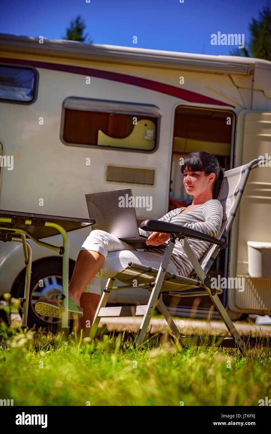 Femme regardant le coffre à côté du camping . Location caravane Vacances. Vacances famille vacances, voyages voyage en camping-car. Informations de connexion wi-fi c Banque D'Images