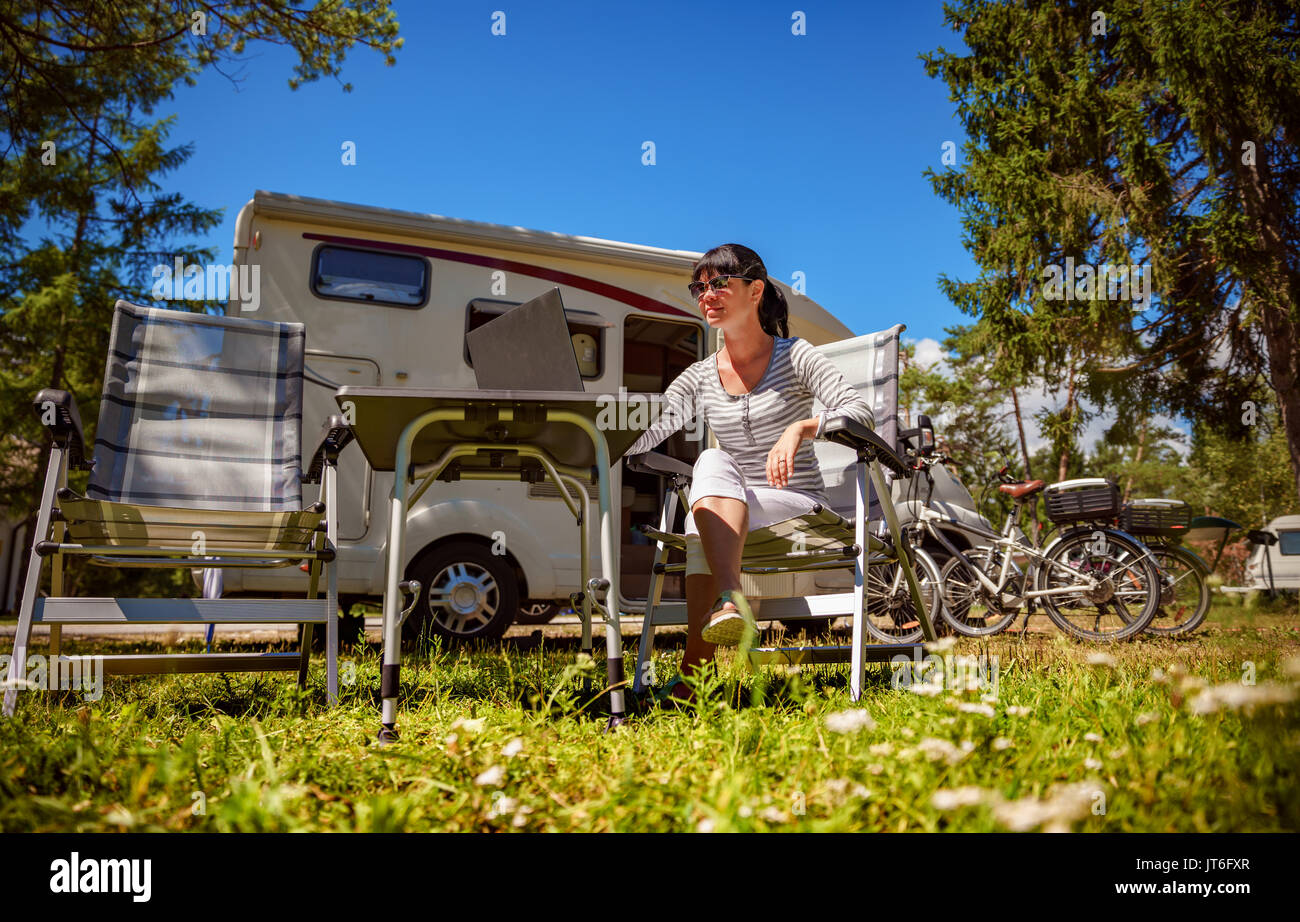 Femme regardant le coffre à côté du camping . Location caravane Vacances. Vacances famille vacances, voyages voyage en camping-car. Informations de connexion wi-fi c Banque D'Images