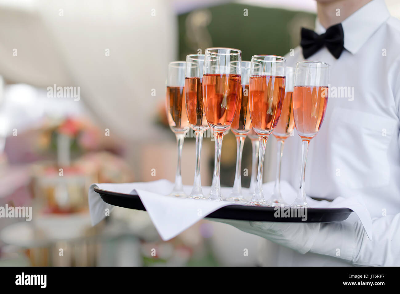 Petit waiter holding tray with glasses Banque D'Images