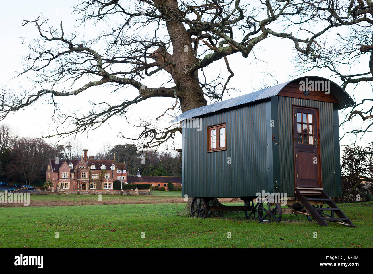 Burley, Hampshire, Royaume-Uni. Petite roulotte en bois avec Burley Manor dans l'arrière-plan. Banque D'Images