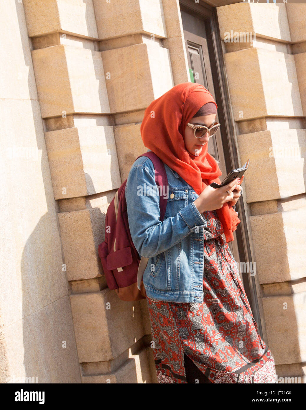 Jeune femme musulmane, le port du foulard coloré jupe et veste en jean et  en utilisant votre téléphone mobile en ville de York, Angleterre Photo  Stock - Alamy