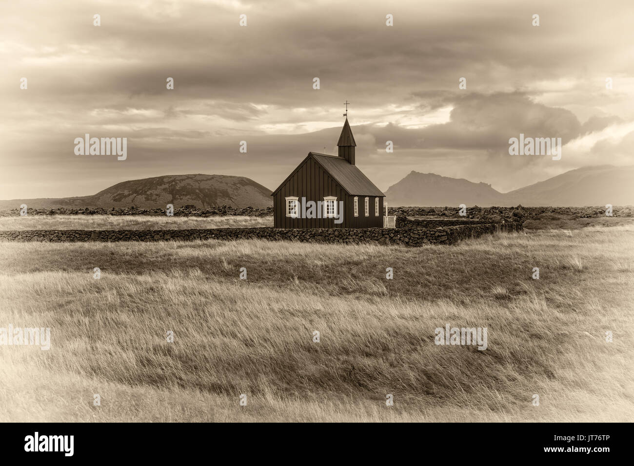 Décor d'église en bois noir de Budir en Islande avec les pâturages et les montagnes en arrière-plan. Vintage noir et blanc traité. Banque D'Images