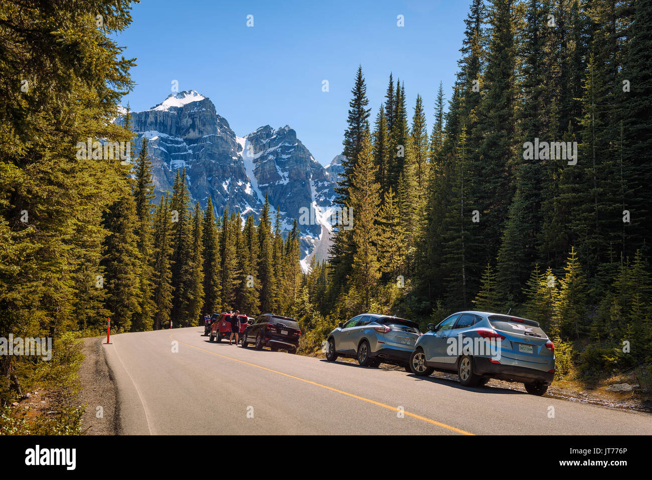 MORAINE LAKE, ALBERTA, CANADA - LE 27 JUIN 2017 : parc de voitures le long de la route pour le lac Moraine, dans le parc national Banff, Alberta, Canada, avec des pe Banque D'Images