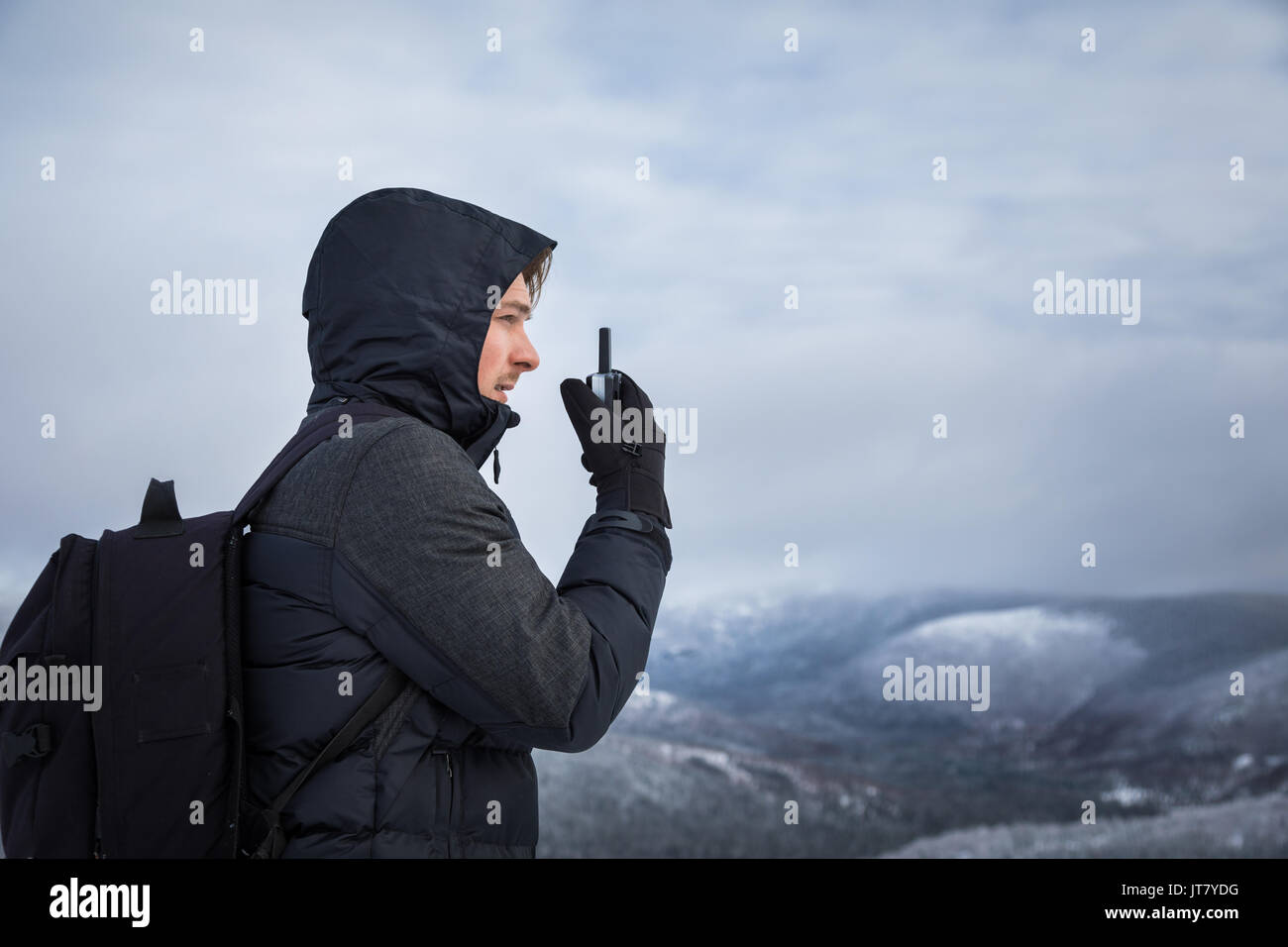 Jeune homme seul sur le haut de la montagne en hiver Banque D'Images