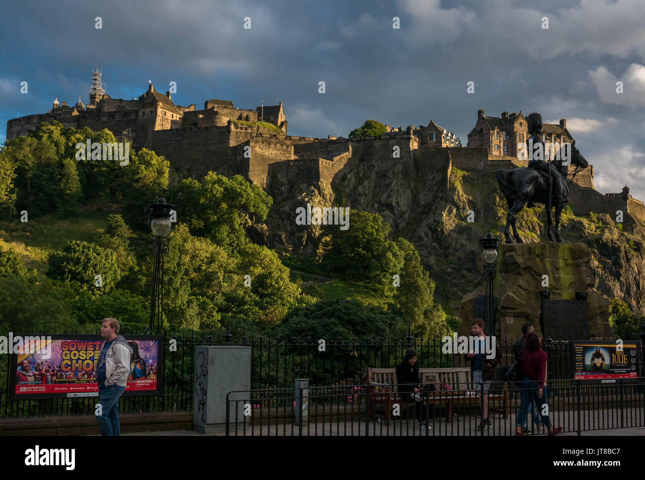 Édimbourg, Écosse, Royaume-Uni, le 7 août 2017. Vue sur le château d'Edimbourg de Princes Street, avec Fringe festival affiches sur les garde-corps et les piétons dans la lumière du soir d'été Banque D'Images