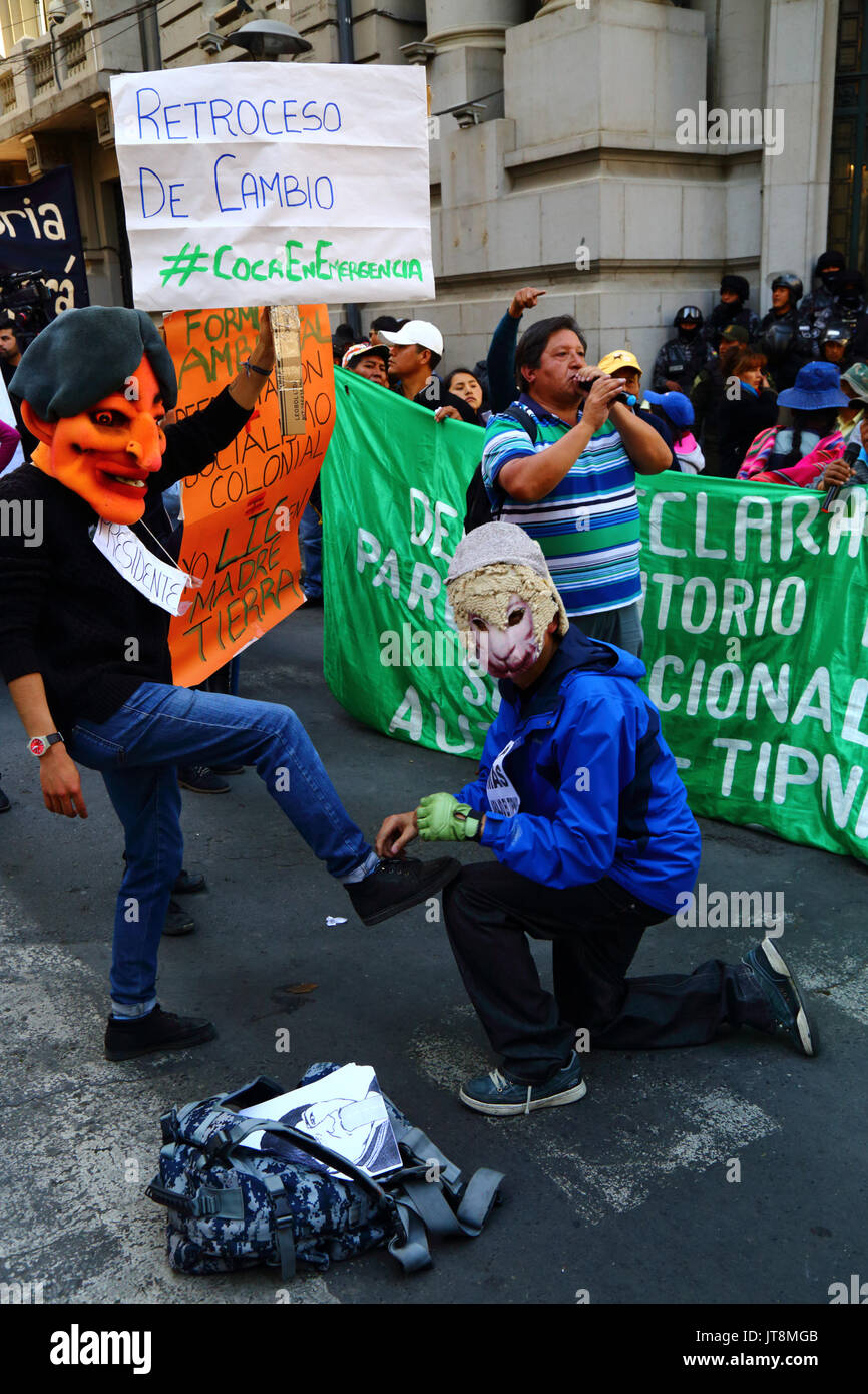 La Paz, Bolivie, le 8 août 2017. Une manifestante vêtue comme une figure d'une brebis (représentant du parti MAS / partisans du gouvernement) des mimes de bloquer le président bolivien Evo Morales' chaussures pendant une marche de protestation pour montrer l'opposition au gouvernement a l'intention d'annuler la Loi 180, qui est débattu aujourd'hui au Sénat. La loi a été créé en 2011 après des manifestations de masse (qui incluait un mois Mars 2 à partir de la région de La Paz) par TIPNIS habitants et beaucoup d'autres anti-gouvernement envisage de construire une route à travers la région sans consultation Credit : James Brunker/Alamy Live News Banque D'Images