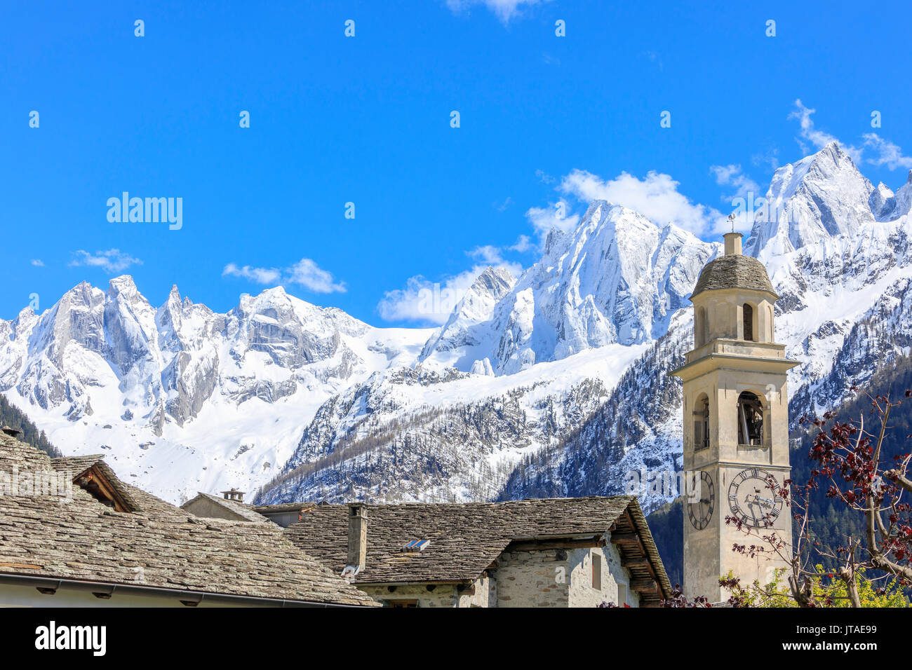 Ciel bleu au printemps sur bell tower et toits en pierre, Soglio, Maloja, Vallée Bregaglia, Engadine, canton des Grisons, Suisse, Europe Banque D'Images