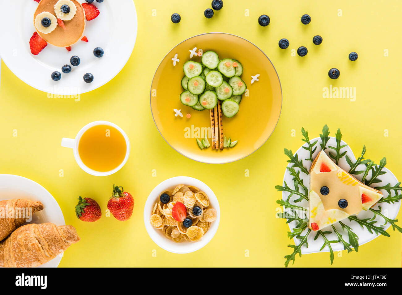 Vue de dessus du style de façon créative le petit déjeuner des enfants avec des croissants et des jus de fruits Banque D'Images