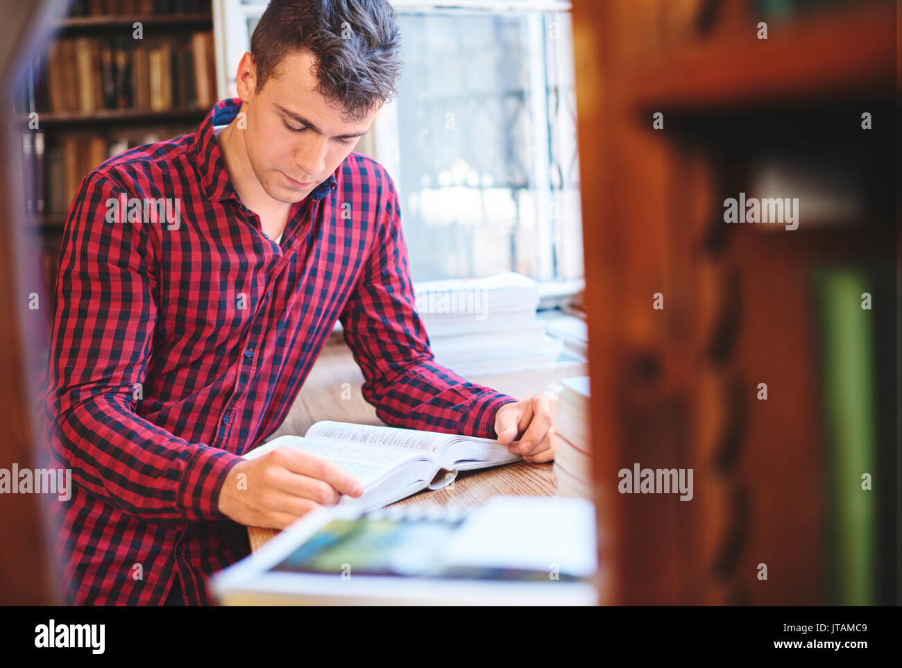 Beau mâle student reading a book Banque D'Images