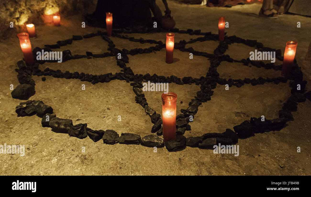 Pentacle satanique avec des bougies allumées, rituel de magie noire de