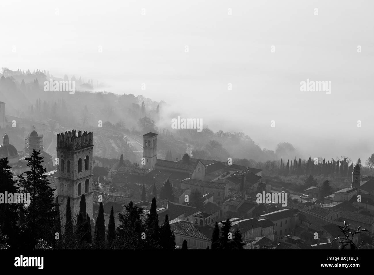 Belle vue d'Assise (Italie) avec du brouillard en dessous et sur l'arrière-plan, et clocher sur l'avant-plan Banque D'Images