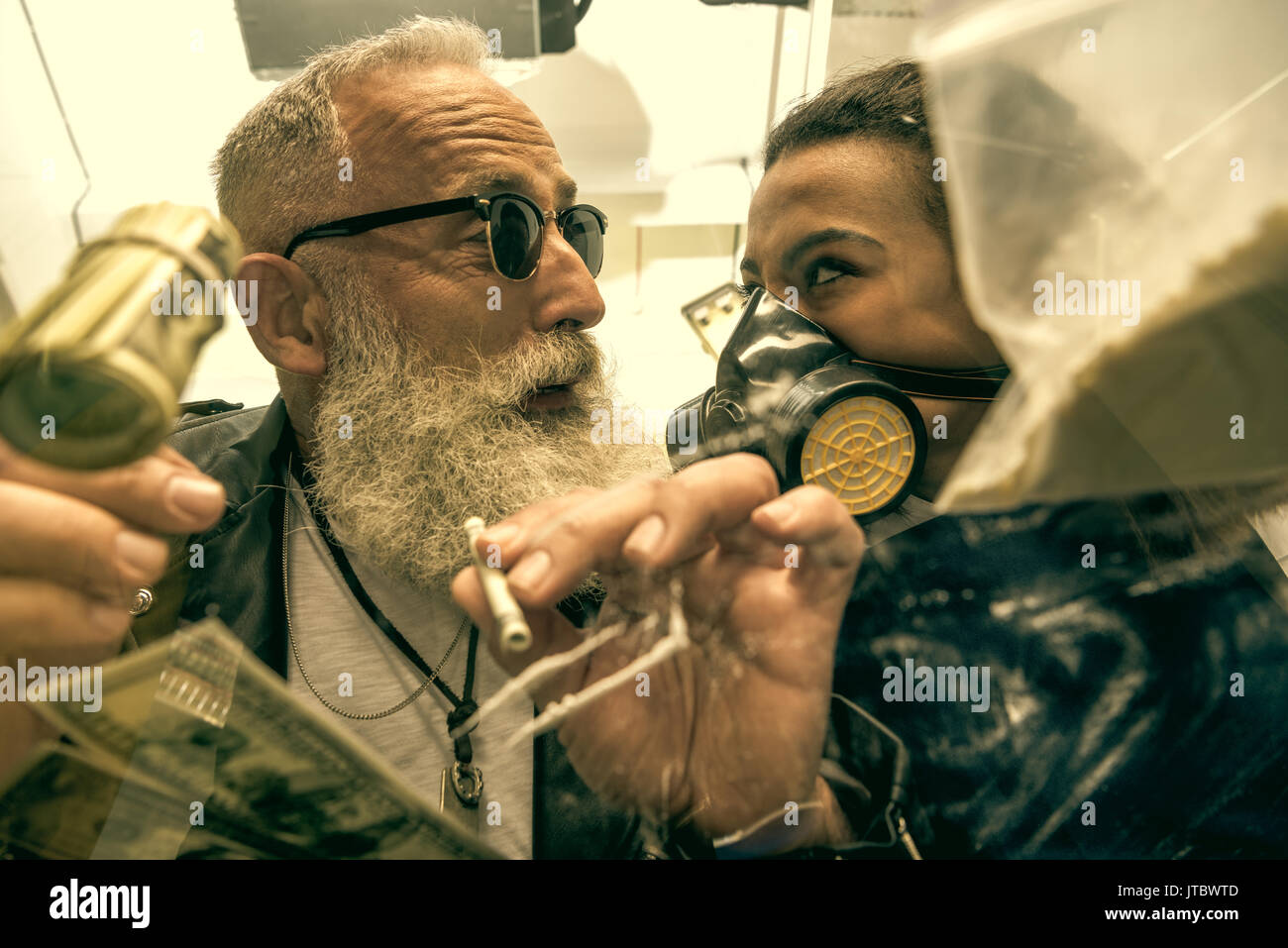 Cheveux gris homme avec barbe prenant des médicaments avec femme dans les équipements de protection individuelle, les drogues concept Banque D'Images