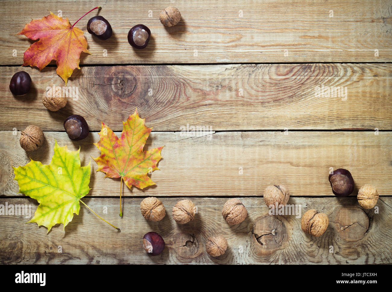 Les feuilles d'automne les noix et les châtaignes sur vieux fond rustique en bois Banque D'Images