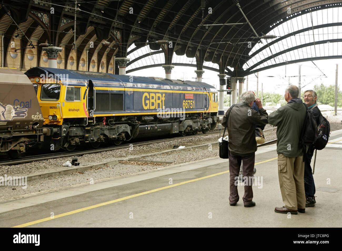 Amateurs de chemin de fer à la gare de New York avec GBRF locomotive classe 66 66751 avec un train de charbon derrière. Banque D'Images