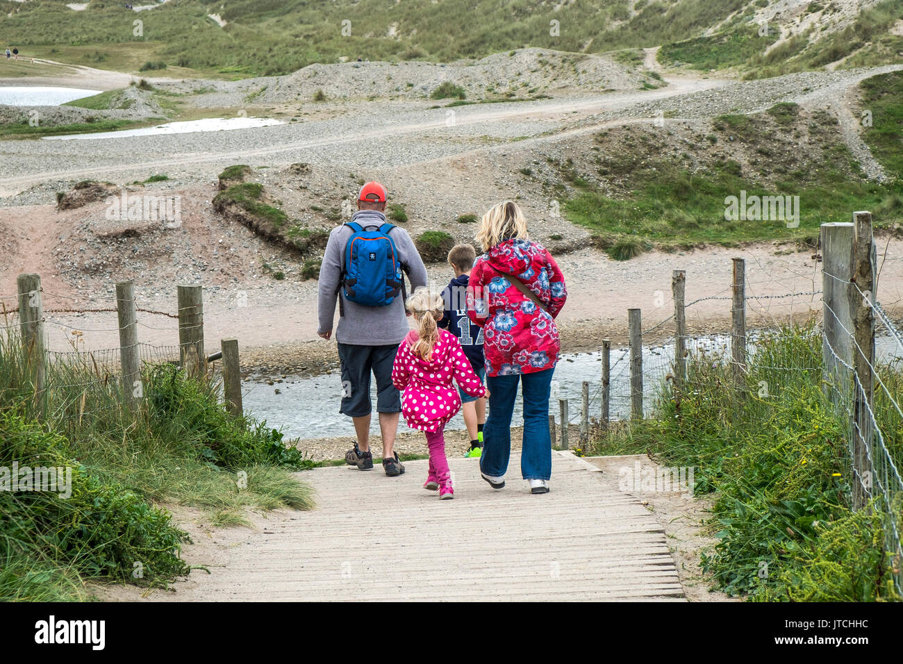 Une famille de vacanciers en vacances sur une promenade de vacances le long d'un sentier de randonnée à Gwithian Towans dans les Cornouailles. Banque D'Images