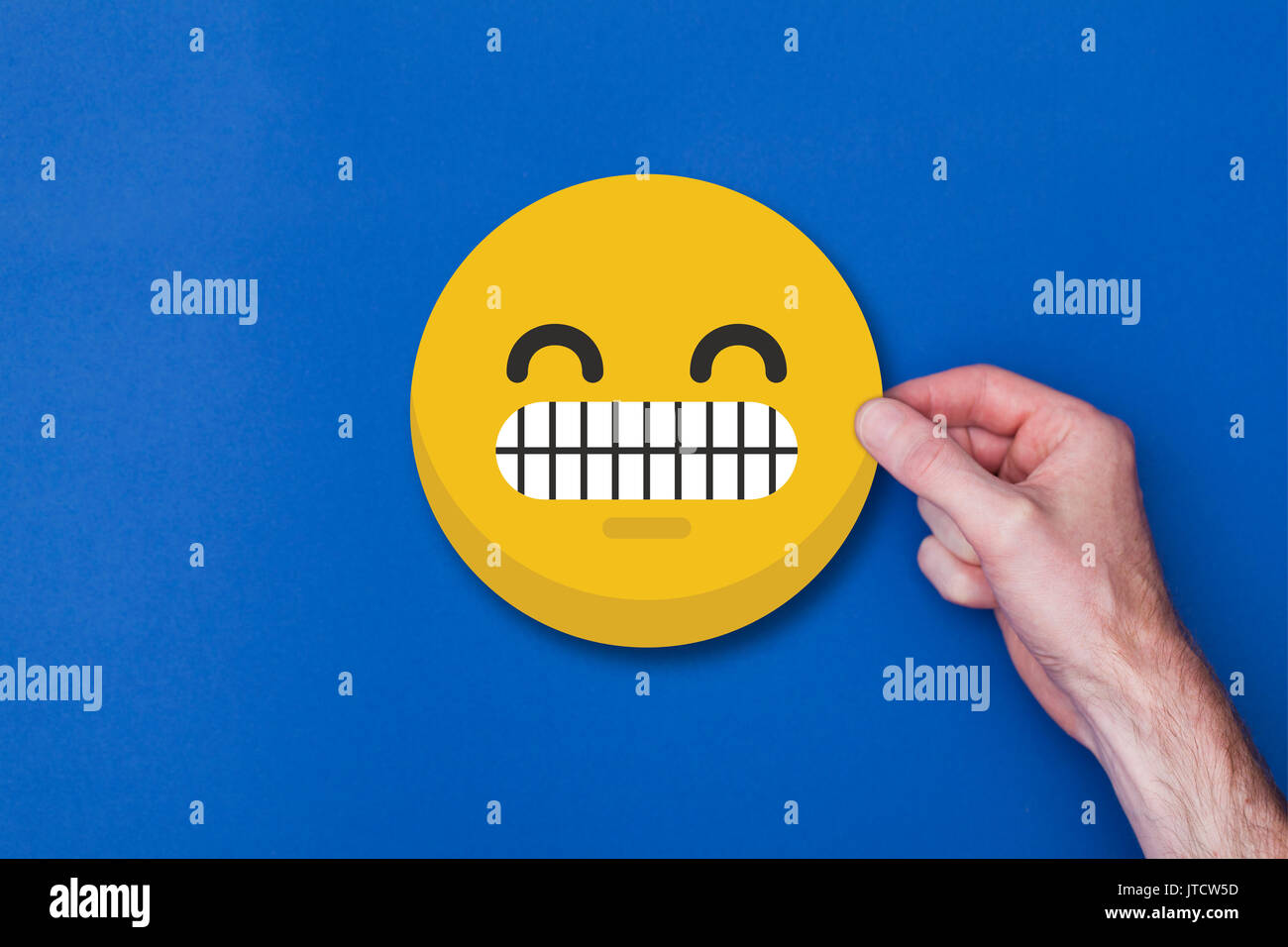 Homme main tenant une émoticône emoji icône smiley chef Banque D'Images