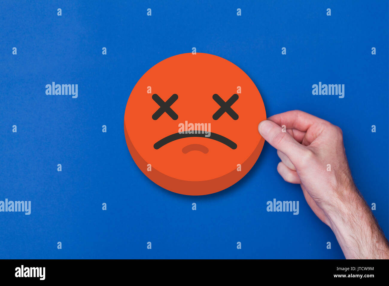 Homme main tenant une émoticône emoji icône smiley chef malheureux Banque D'Images