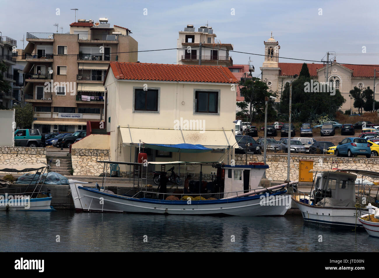 Port de Lavrio Grèce Attique hommes travaillant sur bateau de pêche près d'une maison Banque D'Images