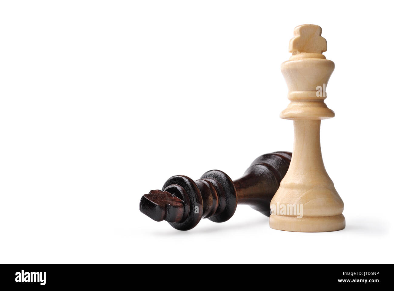 Deux roi en bois pièces des échecs sur blanc, un en bois clair debout et le sombre roi couché sur le côté avec copyspace Banque D'Images