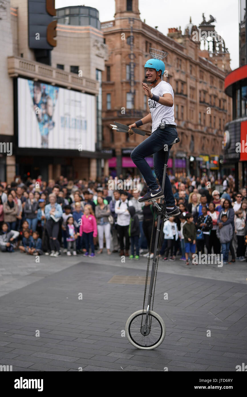 Un juggling unicyclist effectuer pour les foules à Leicester Square à Londres. À partir d'une série de photos d'artistes de rue, à Londres, au Royaume-Uni. Date de la photo : T Banque D'Images