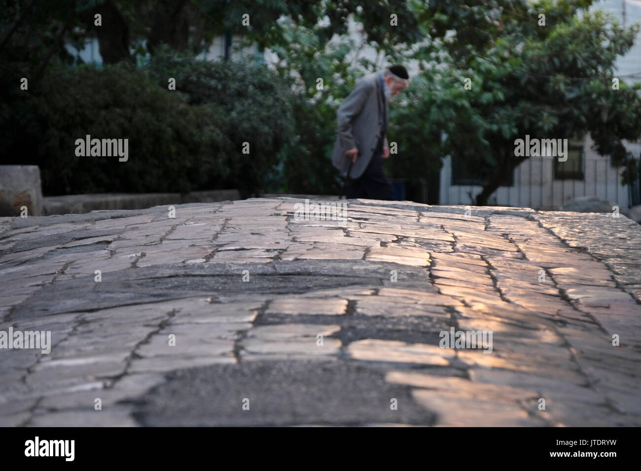Un juif religieux traversant une ruelle d'Ohel Moshe ancien quartier cour fondée en 1883 à Nachlaot ou Nahlaot un regroupement de 23 quartiers ancienne cour qui peuplaient la nouvelle ville après avoir quitté la ville fortifiée de Jérusalem à la fin du 19e siècle situé dans l'ouest de Jérusalem Israël Banque D'Images